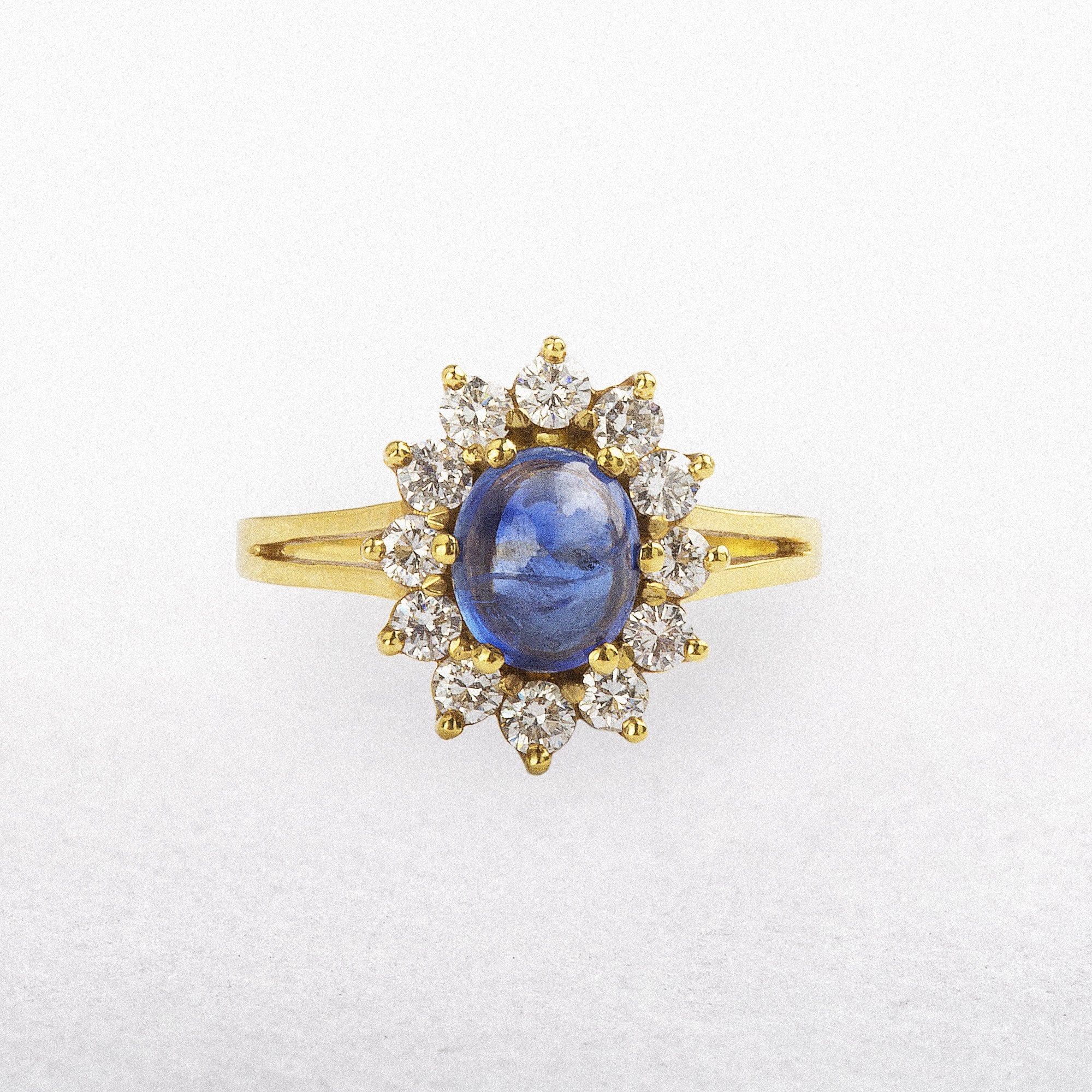 18ct yellow gold oval Cabochon sapphaire 1.31ct, diamond halo 0.57ct ring